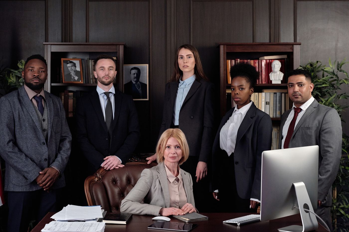A law firm team gathered in a panelled office.